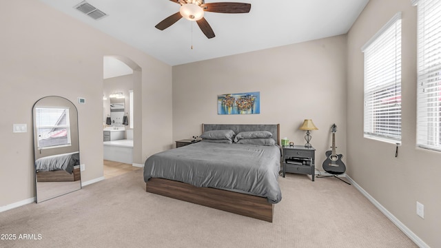 bedroom featuring multiple windows, visible vents, carpet flooring, and arched walkways