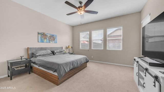 bedroom with light colored carpet, a ceiling fan, and baseboards