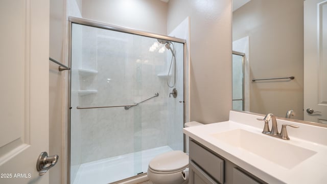 full bath featuring toilet, a stall shower, and vanity
