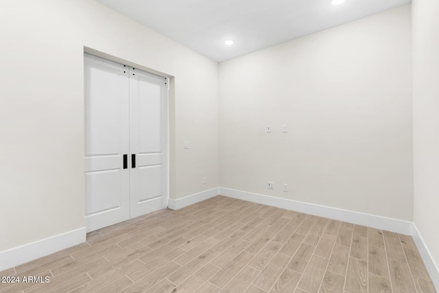unfurnished room with light wood-type flooring, baseboards, and recessed lighting