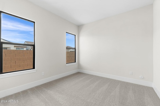 unfurnished room with carpet and baseboards
