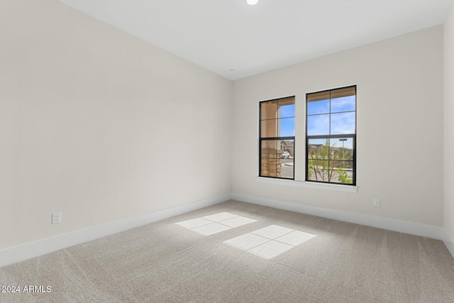 spare room featuring carpet floors and baseboards