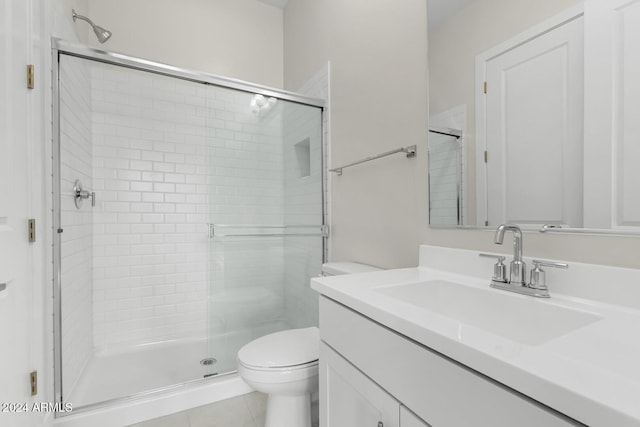 bathroom with a stall shower, vanity, toilet, and tile patterned floors