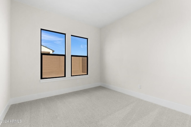 unfurnished room with carpet flooring and baseboards