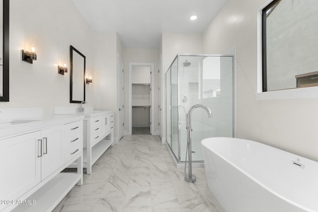 full bath with a stall shower, a soaking tub, marble finish floor, a walk in closet, and vanity