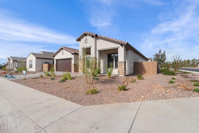 view of front facade featuring concrete driveway, stone siding, a tile roof, an attached garage, and stucco siding