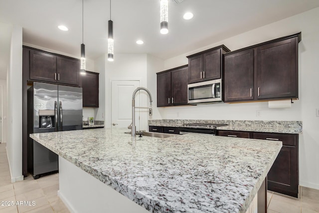 2792 E James Ave, San Tan Valley, AZ 85143 - kitchen with stainless steel appliances, a center island with sink, a sink, light stone countertops, and dark brown cabinets