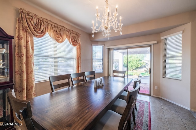 tiled dining room featuring an inviting chandelier