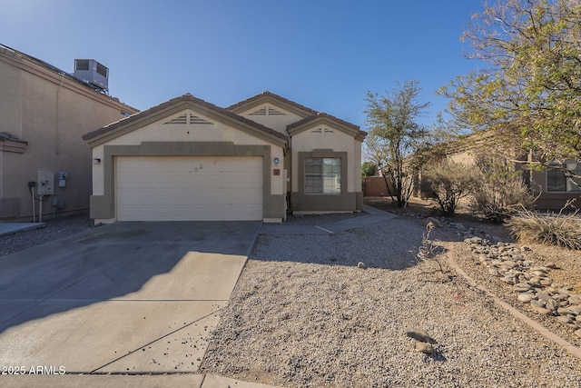 view of front facade featuring concrete driveway, a tile roof, an attached garage, central air condition unit, and stucco siding