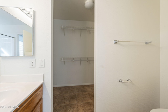 full bathroom with a spacious closet, tile patterned flooring, and vanity