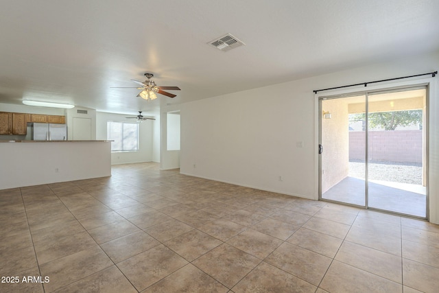 interior space with light tile patterned floors, ceiling fan, and visible vents