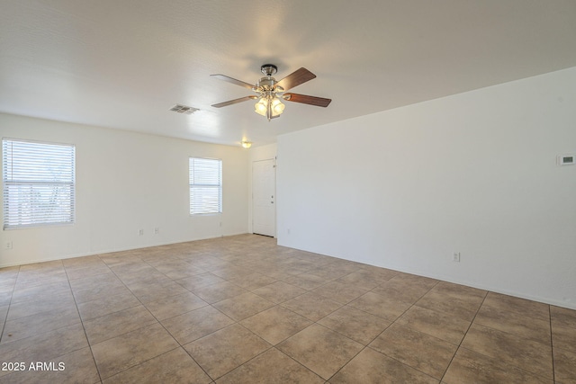 unfurnished room featuring a ceiling fan, visible vents, and light tile patterned floors