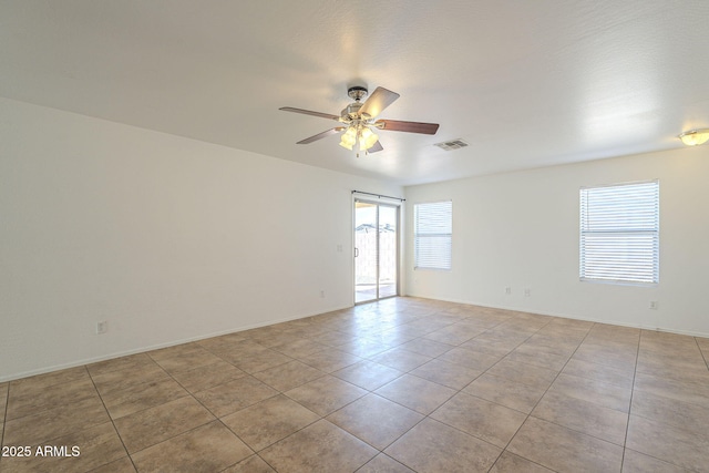 unfurnished room with light tile patterned floors, baseboards, visible vents, and a ceiling fan