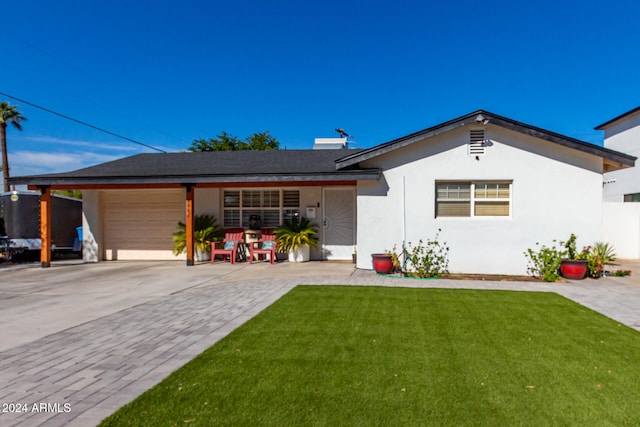 single story home with a garage and a front lawn