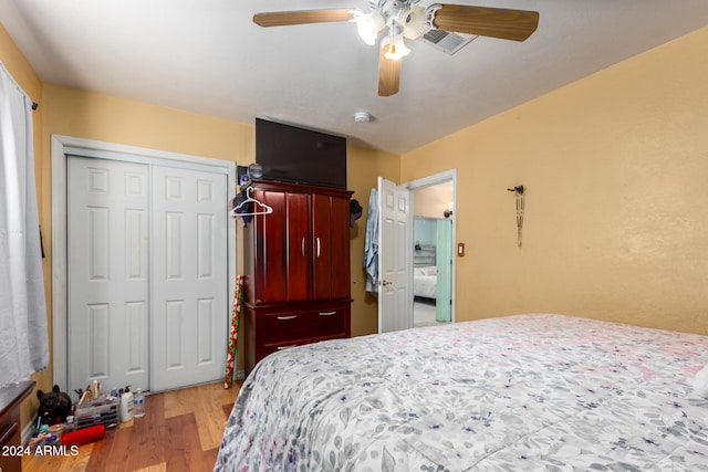 bedroom with light wood-type flooring, ceiling fan, and a closet