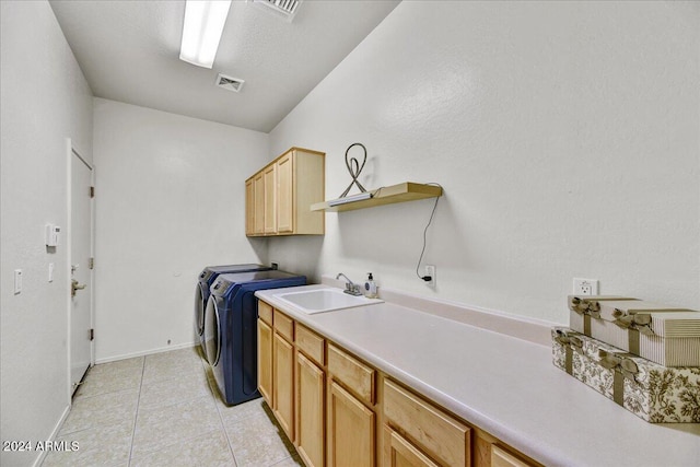 washroom with washer and clothes dryer, cabinets, light tile patterned floors, and sink