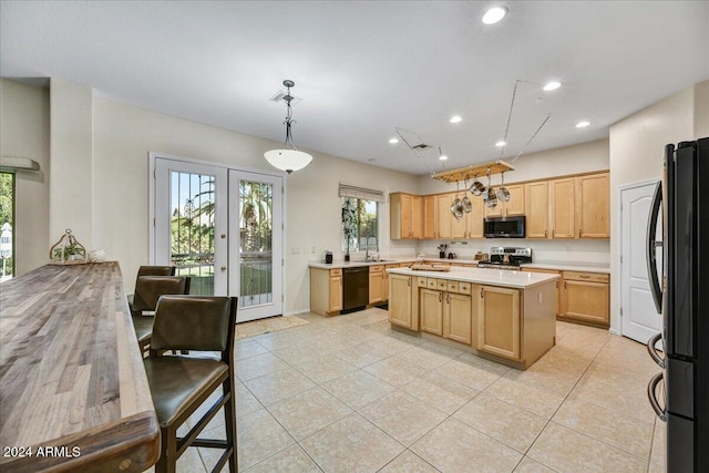 kitchen with a center island, french doors, light brown cabinets, decorative light fixtures, and black appliances