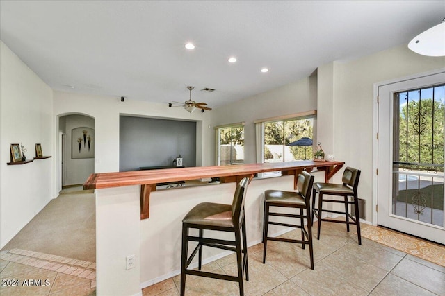 kitchen featuring plenty of natural light, a kitchen bar, and kitchen peninsula