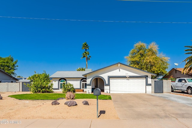 ranch-style house featuring stucco siding, driveway, an attached garage, and fence