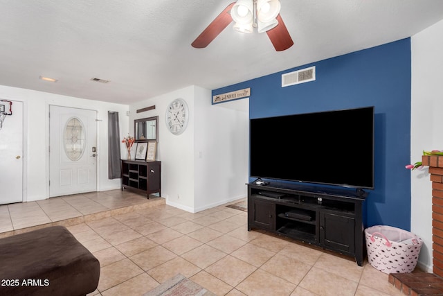 living room featuring visible vents, ceiling fan, and light tile patterned floors