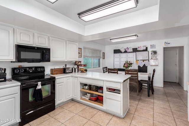 kitchen featuring white cabinets, a peninsula, light countertops, black appliances, and light tile patterned flooring