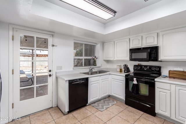 kitchen featuring white cabinets, light countertops, black appliances, a sink, and light tile patterned flooring