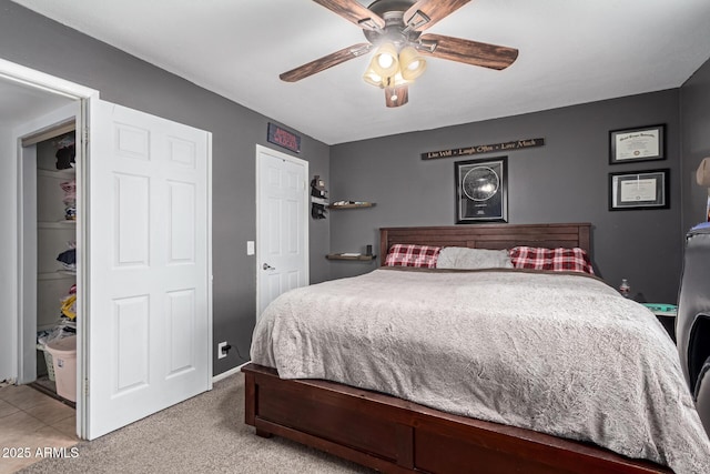 bedroom featuring ceiling fan, a closet, baseboards, and light colored carpet