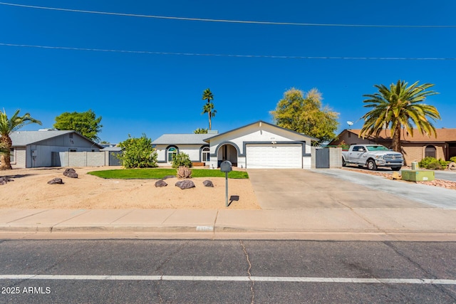 ranch-style home with driveway, an attached garage, and fence