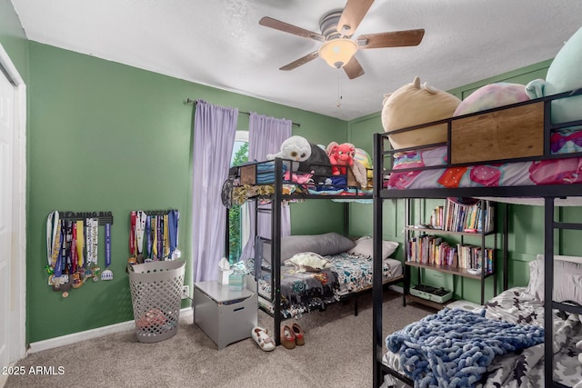 carpeted bedroom with a textured ceiling, ceiling fan, and baseboards