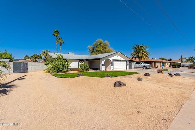 ranch-style home with driveway, an attached garage, a gate, and fence