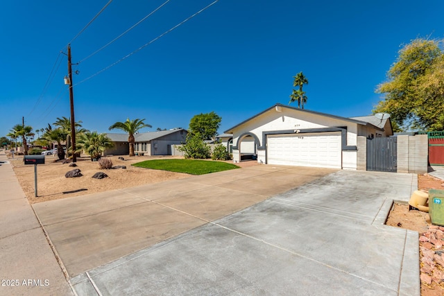 ranch-style home featuring stucco siding, a gate, fence, a garage, and driveway