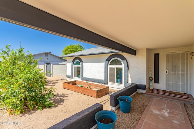 view of patio with a garden and fence