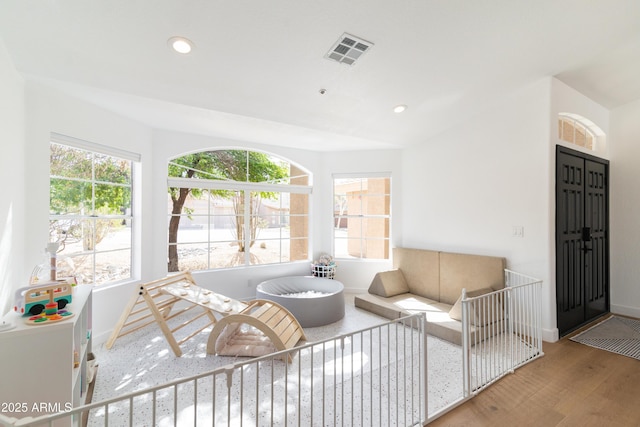 living area with plenty of natural light, visible vents, wood finished floors, and recessed lighting