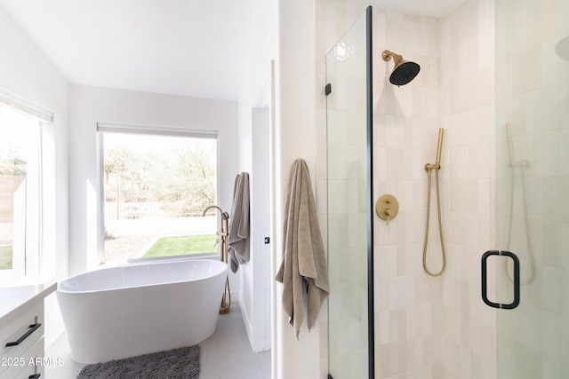 bathroom featuring a stall shower, tile patterned floors, vanity, and a soaking tub