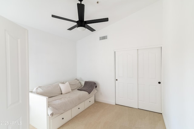 bedroom with light carpet, baseboards, visible vents, vaulted ceiling, and a closet