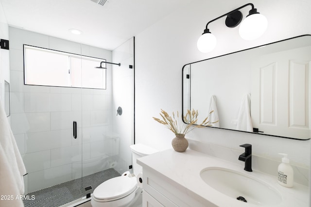 full bathroom featuring a stall shower, vanity, and toilet