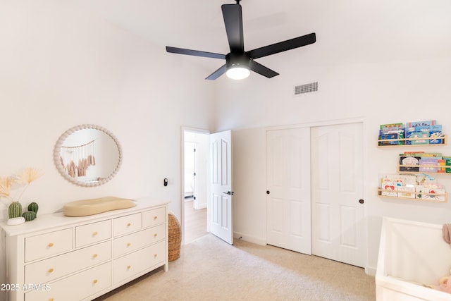 bedroom with light colored carpet, a ceiling fan, baseboards, visible vents, and a closet