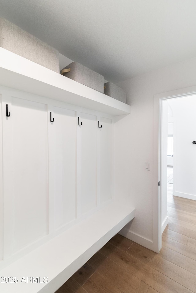 mudroom featuring wood finished floors and baseboards