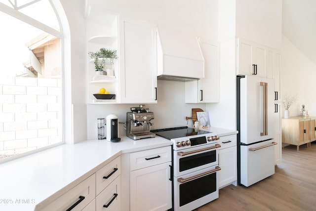 kitchen with white appliances, white cabinetry, light wood-type flooring, custom exhaust hood, and open shelves