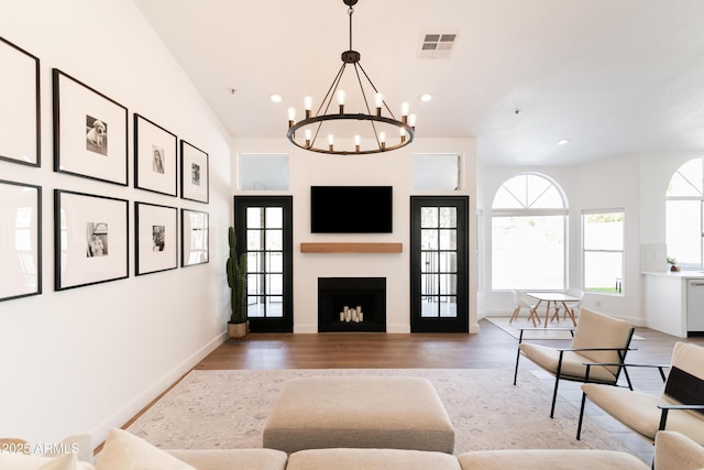 living room featuring light wood-type flooring, visible vents, a fireplace, and recessed lighting