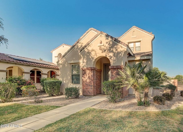 mediterranean / spanish house featuring a front yard