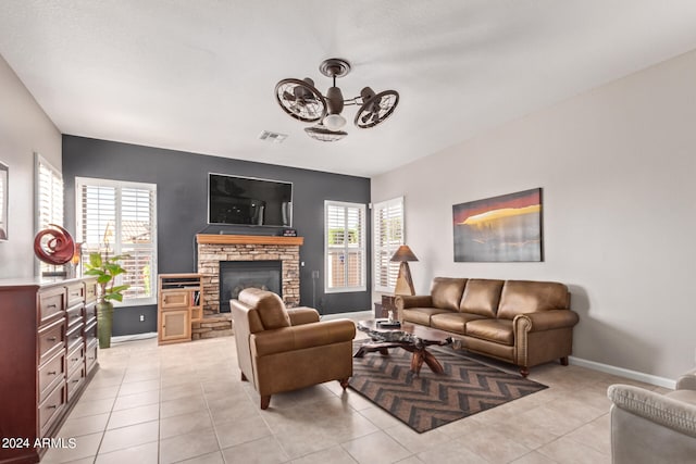 tiled living room featuring a fireplace, ceiling fan, and a healthy amount of sunlight