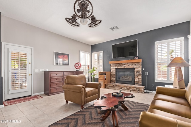 tiled living room with plenty of natural light, ceiling fan, and a fireplace