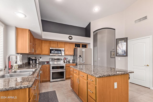 kitchen with a center island, dark stone countertops, sink, and appliances with stainless steel finishes