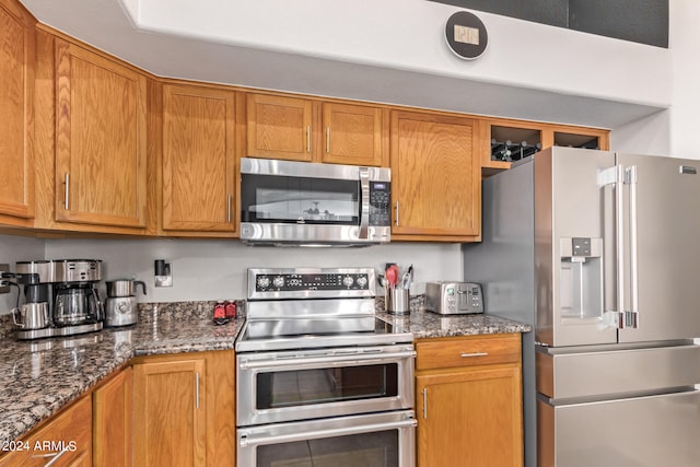 kitchen with dark stone countertops and stainless steel appliances