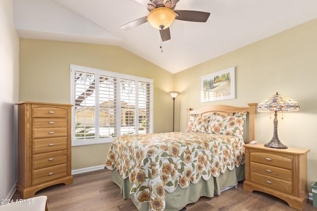 bedroom featuring ceiling fan, hardwood / wood-style floors, and lofted ceiling