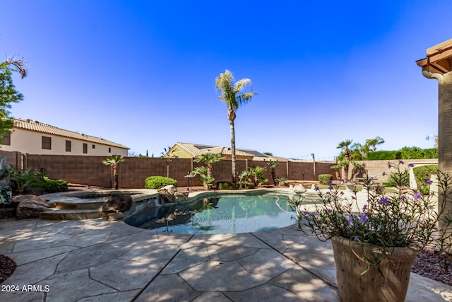 view of pool with a patio area and an in ground hot tub