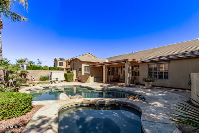 view of swimming pool featuring a patio area and an in ground hot tub