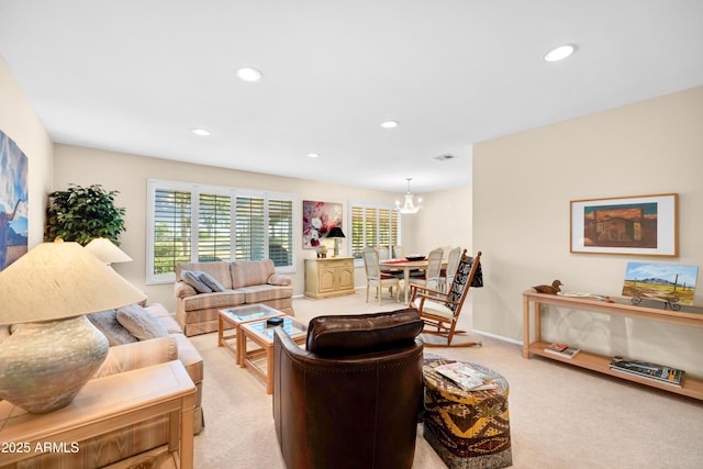 carpeted living room featuring an inviting chandelier