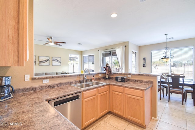 kitchen with decorative light fixtures, dishwasher, sink, light tile patterned floors, and kitchen peninsula